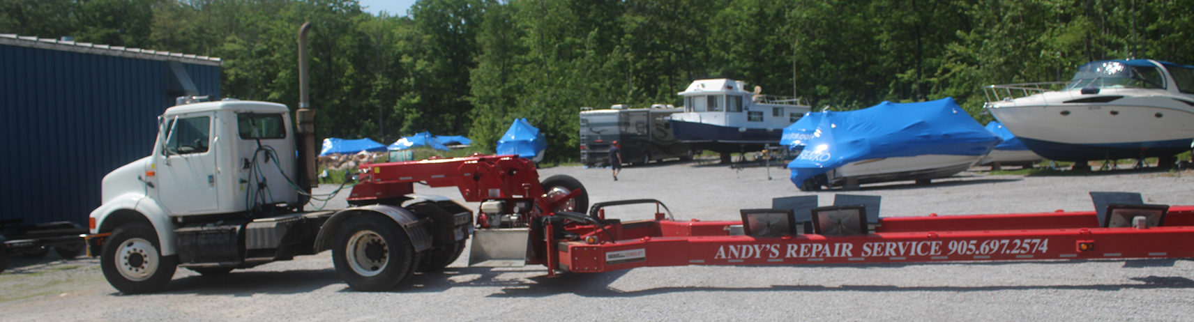 A photo of our boat tractor trailer, a white cab truck with a red trailer
